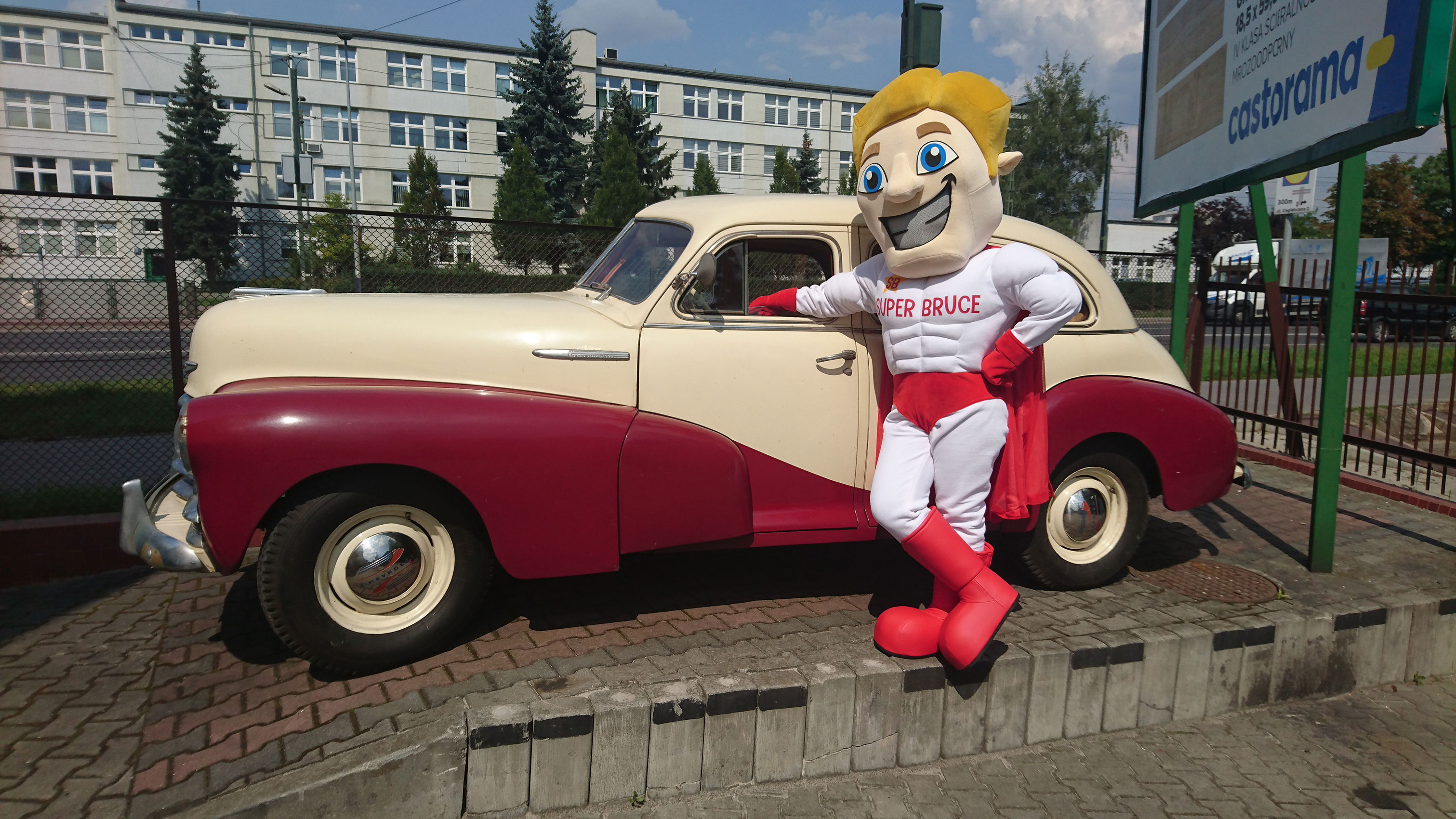 Na fotografii widnieje strój reklamowy w postaci chłopca Super Bruce